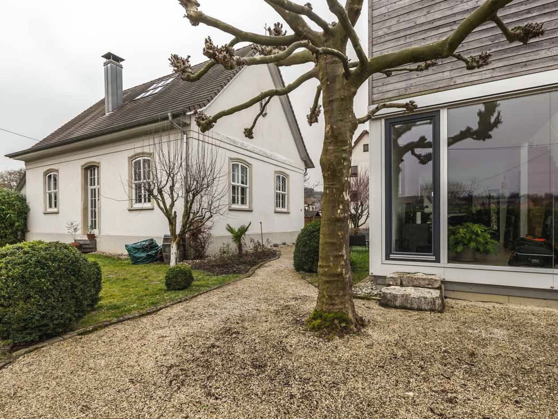 Auf der linken Seite Frontansicht des alten Gemeindehauses, auf der rechten Seite Frontansicht des neuen Büros