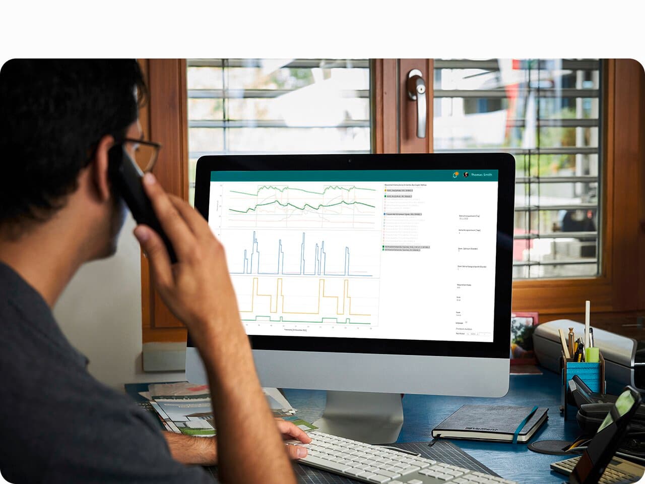 Mann sitzt vor einem Bildschirm und prüft die Daten eines Wärmepumpensystems