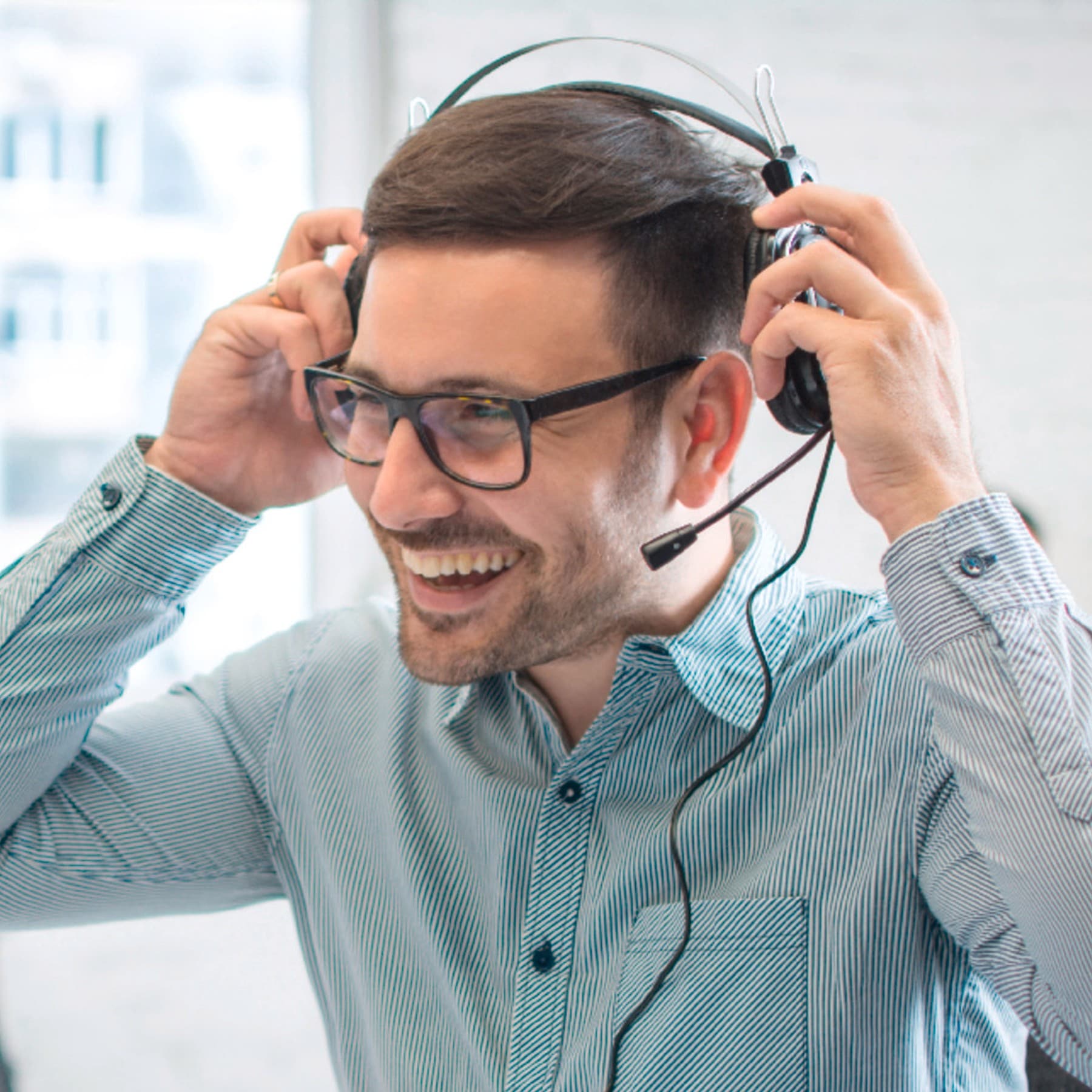 Mann sitzt mit Headset im Callcenter.