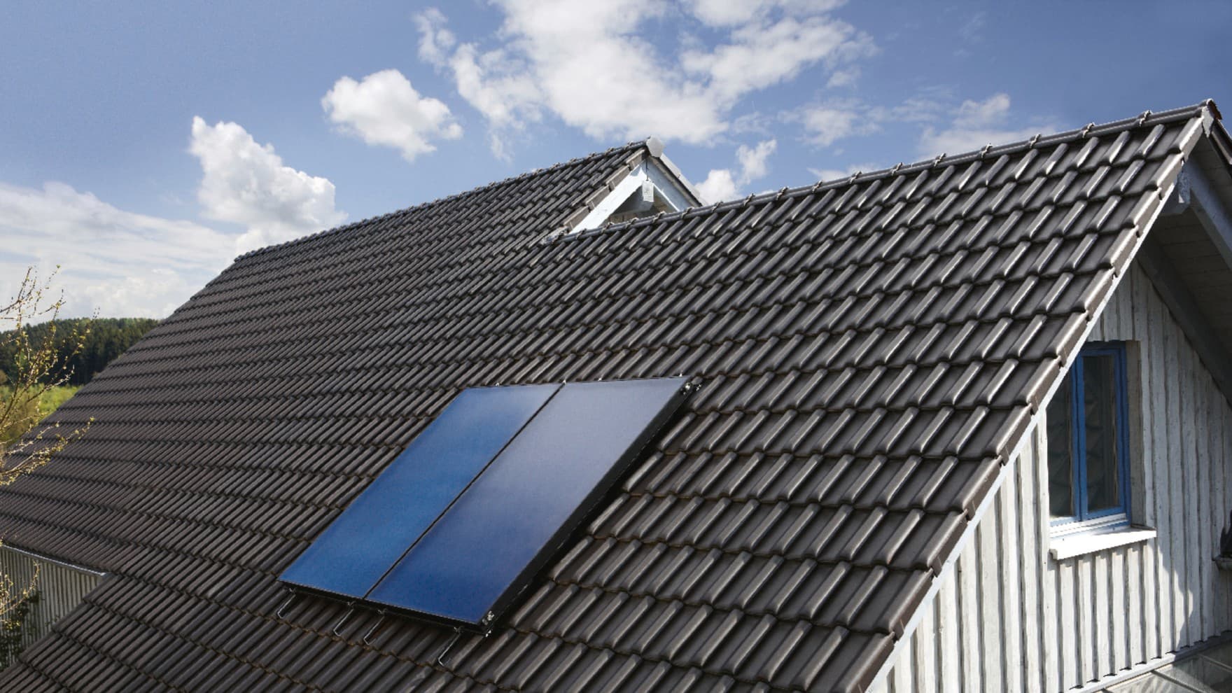 Ein Hausdach mit einem Flachkollektor.