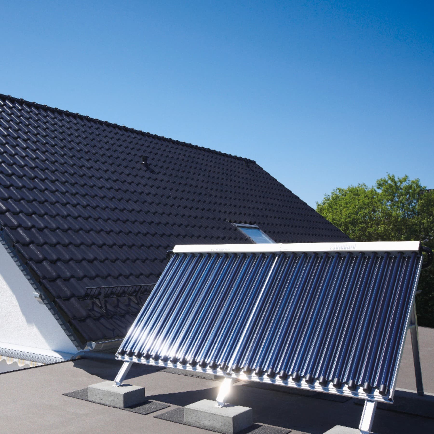 Solarthermie-Kollektor auf einem Hausdach unter klarem, blauem Himmel