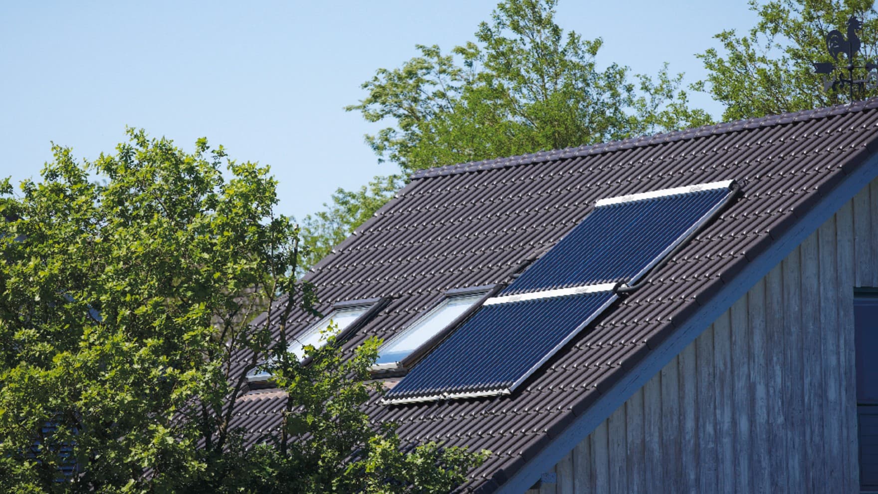 Ein Hausdach mit zwei Solarpaneelen.