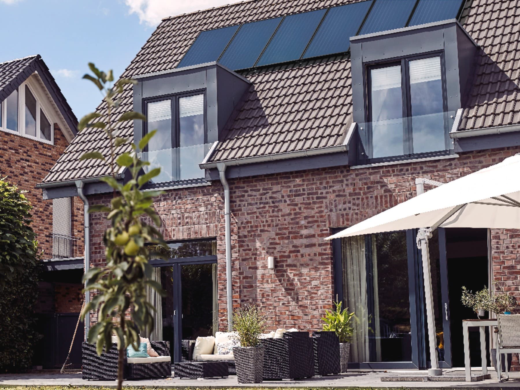 Ein Backsteingebäude mit einer Solaranlage auf dem Dach.