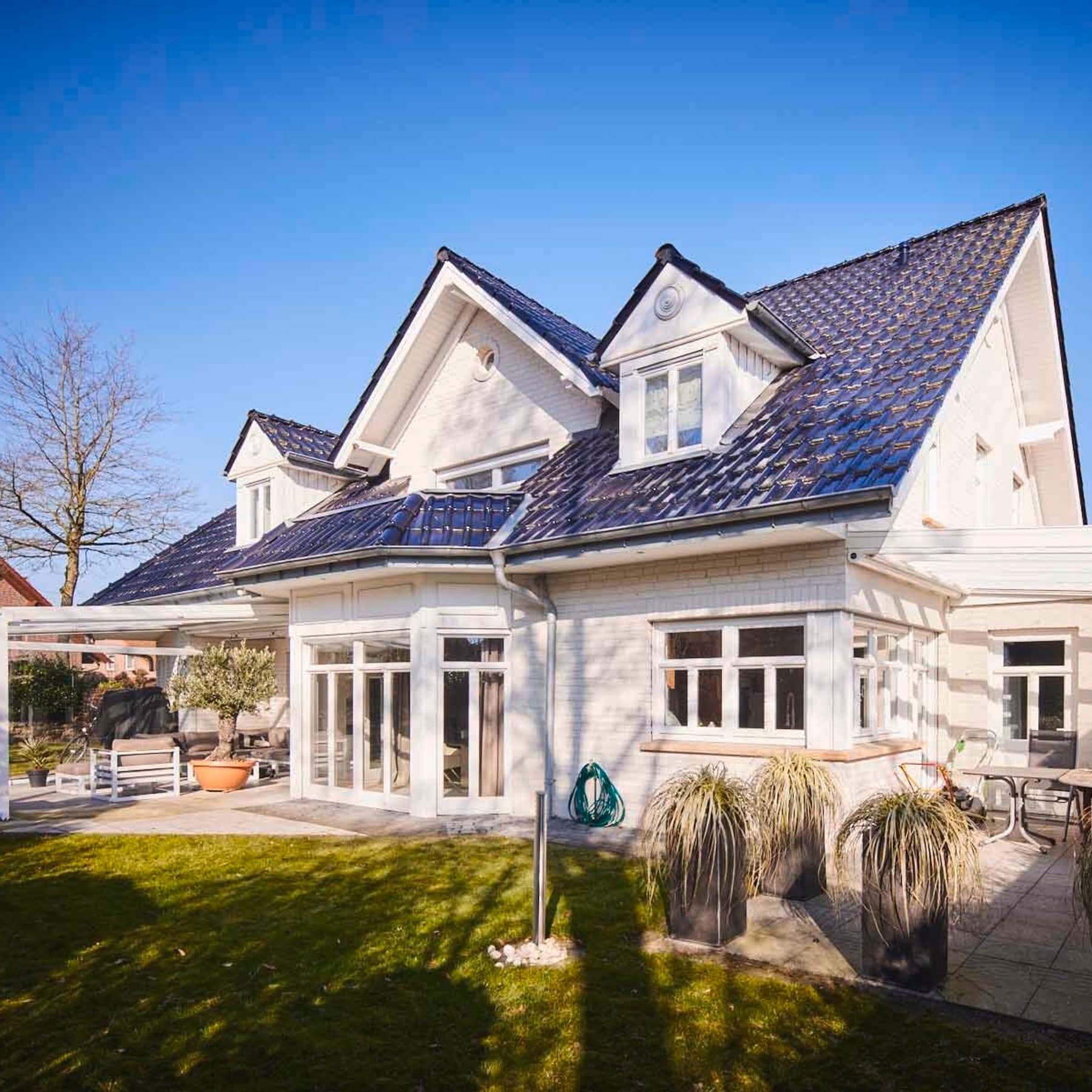 Rückansicht auf das Einfamilienhaus und den Garten mit Terrasse