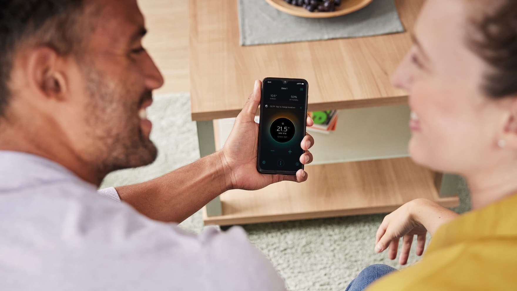 Pärchen mit einem Smartphone in der Hand, auf dem die myVAILLANT App geöffnet ist.