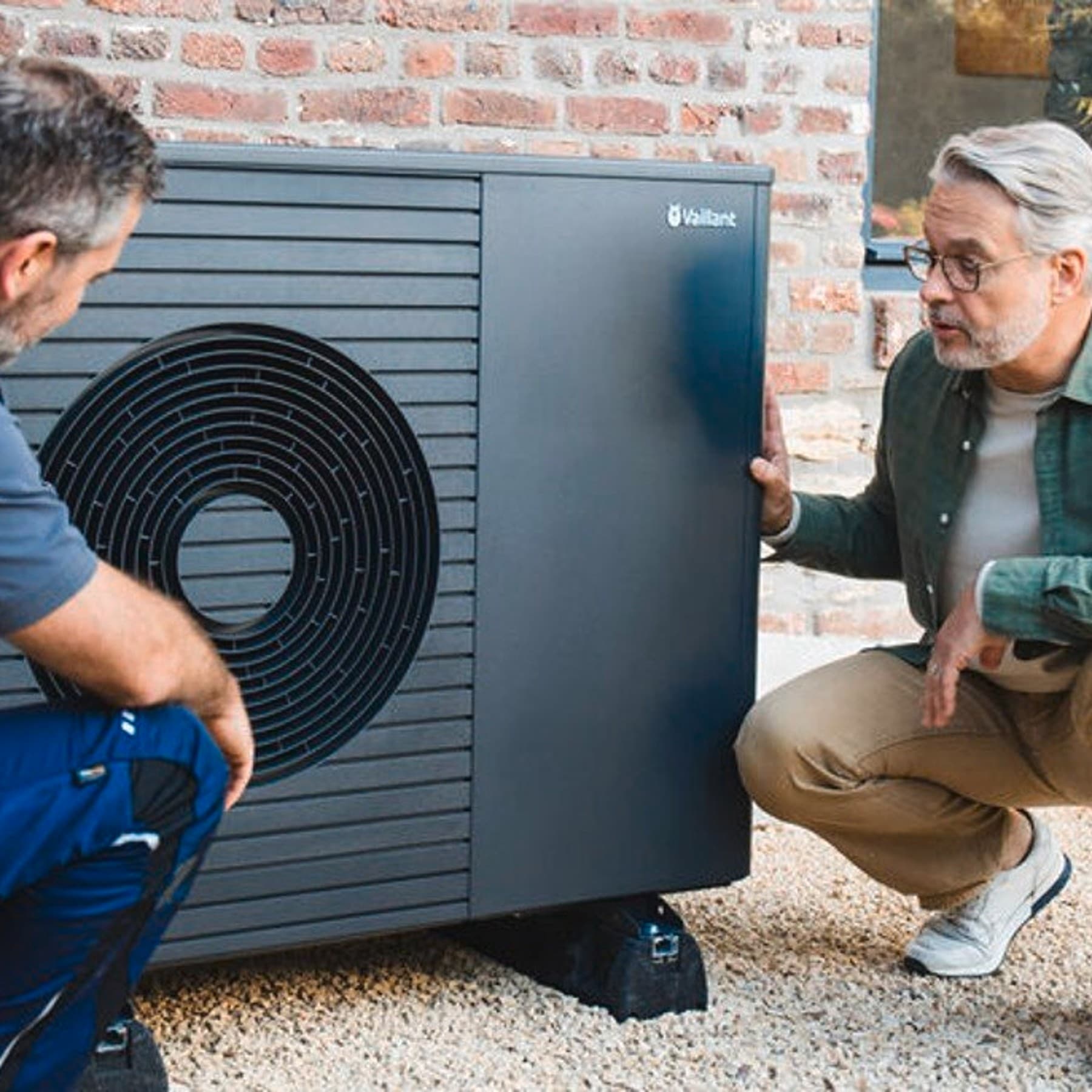 Installer explains something about a heat pump to the customer