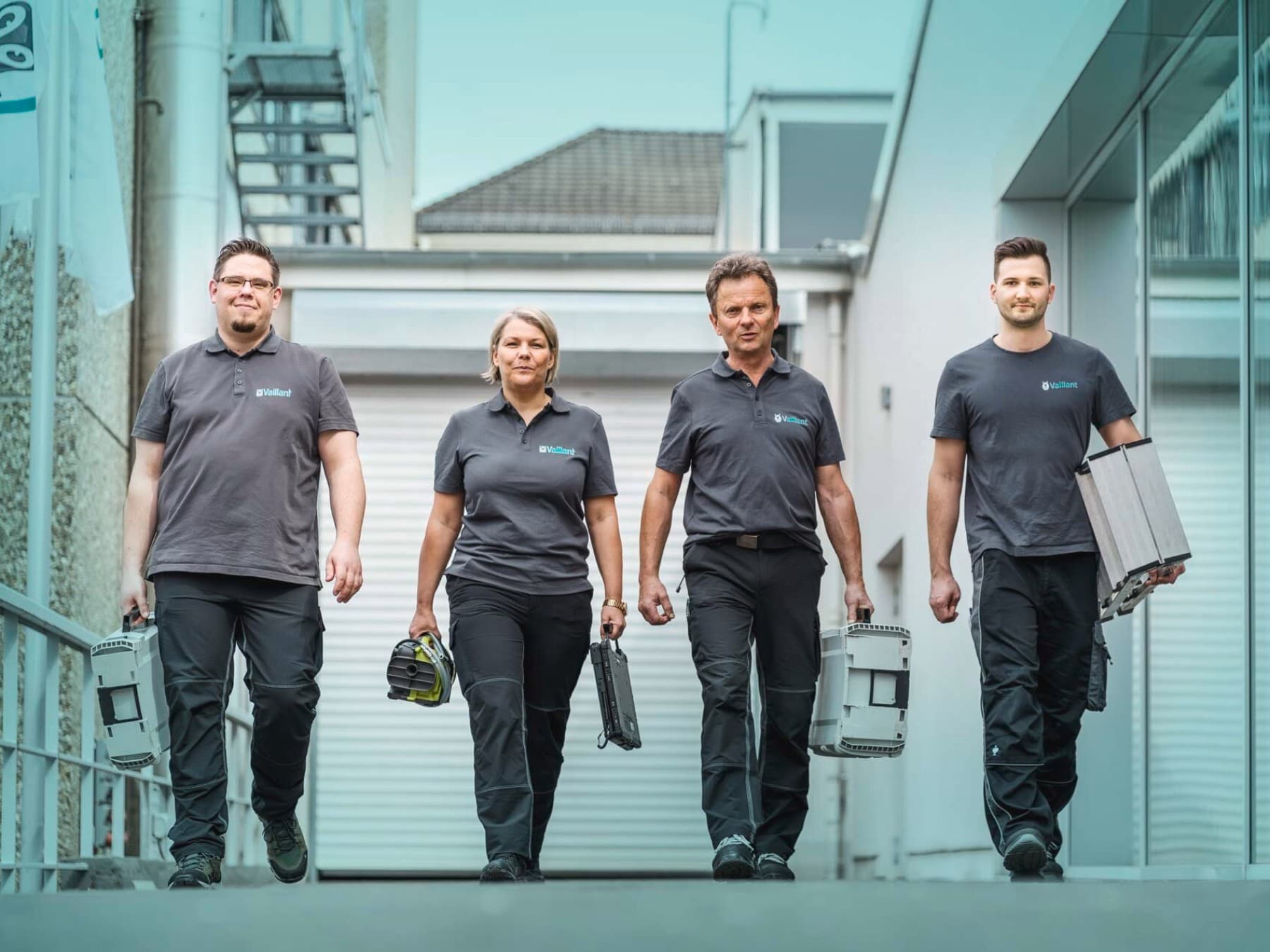 Mehrere Vaillant Mitarbeitende mit Arbeitsutensilien in der Hand