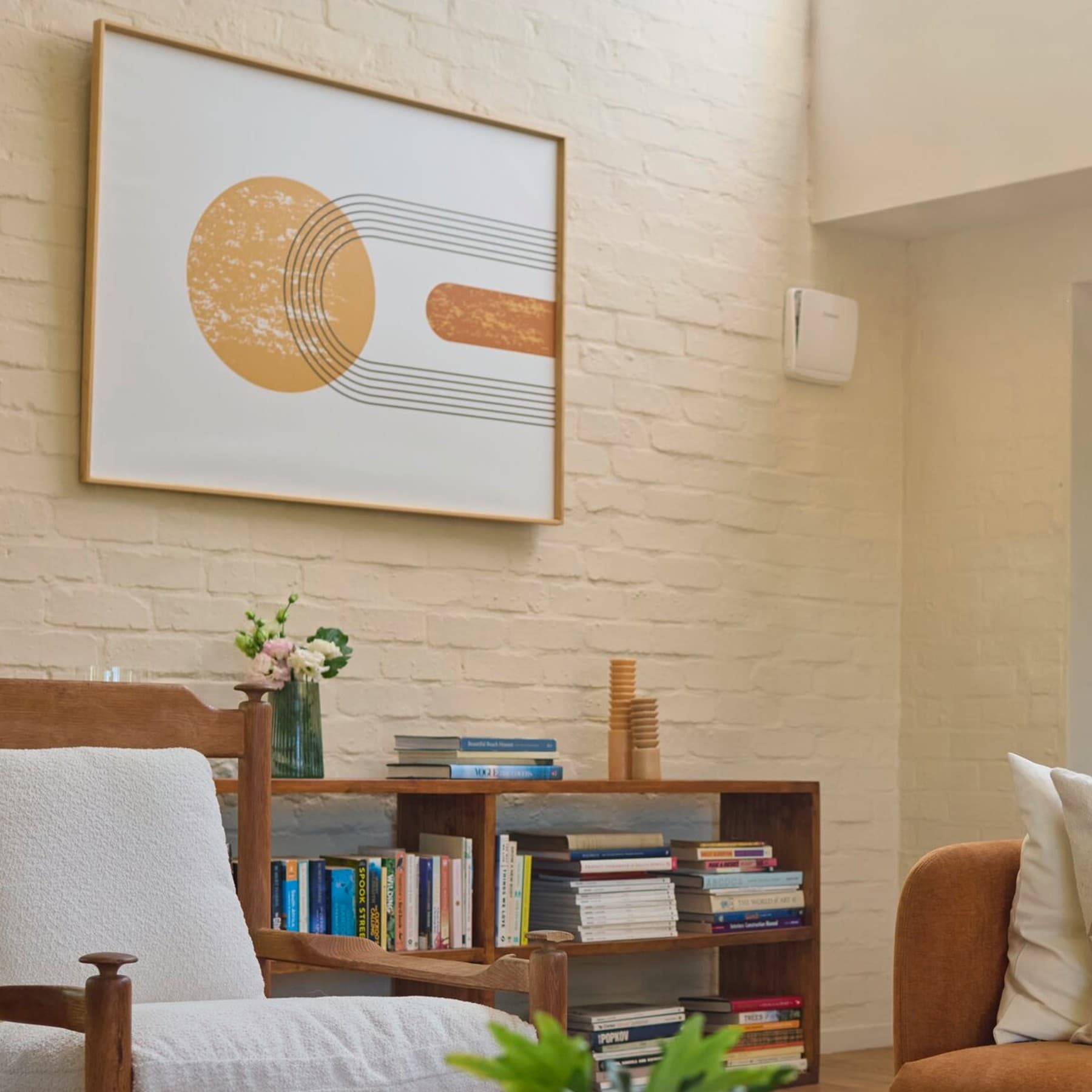 Dezentrale Wohnraumlüftung recoVAIR 60 von Vaillant hängt in einem Wohnzimmer unauffällig an der Wand