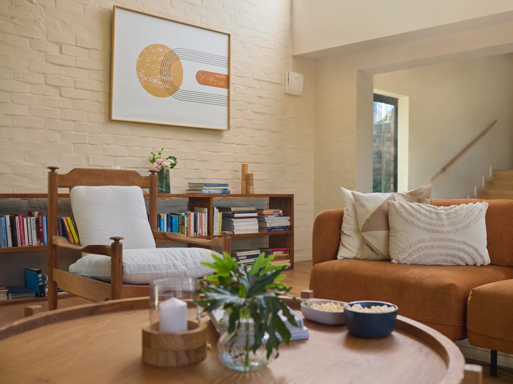 Dezentrale Wohnraumlüftung recoVAIR 60 von Vaillant hängt in einem Wohnzimmer unauffällig an der Wand