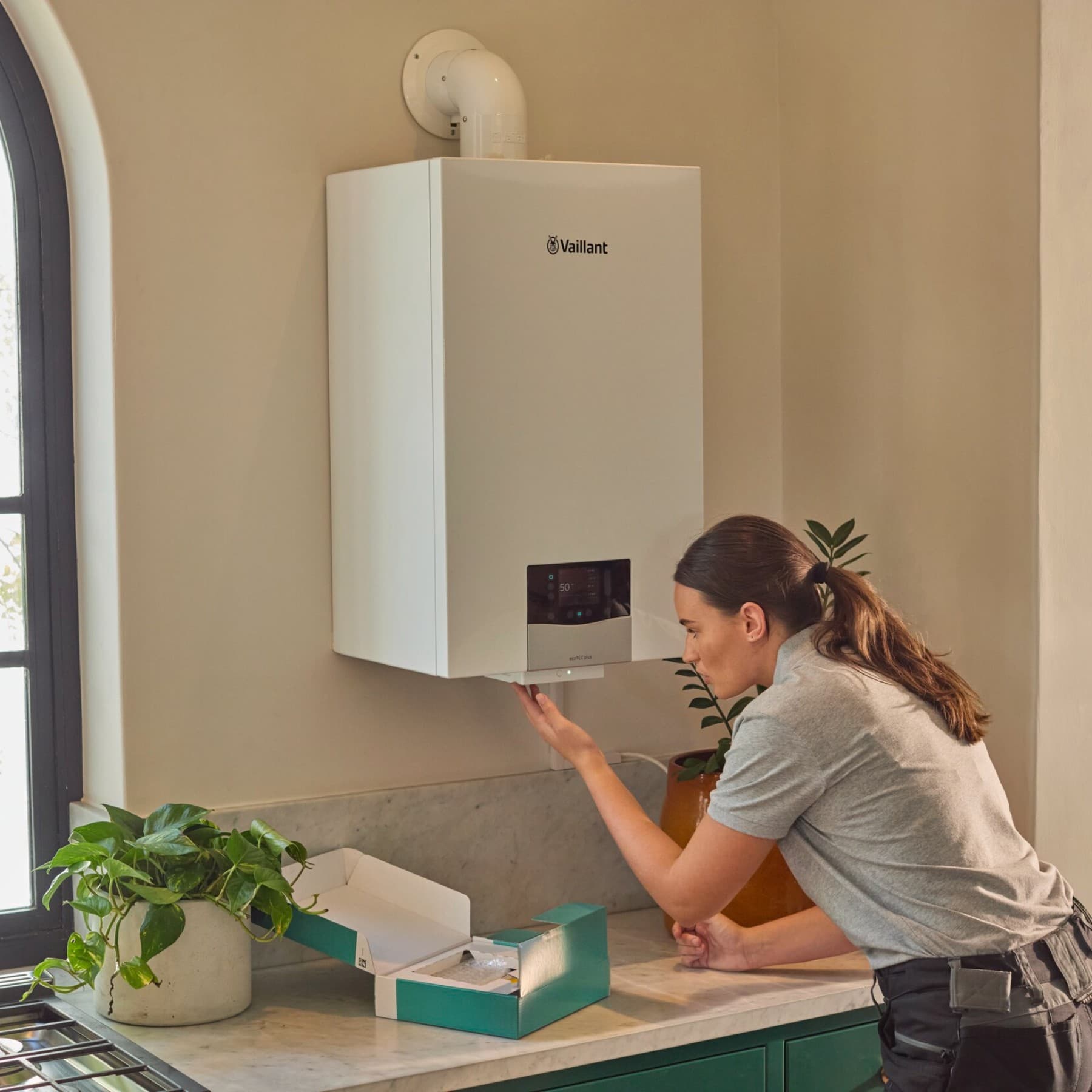 Eine Fachhandwerkerin an einem Vaillant Gas-Brennwertgerät