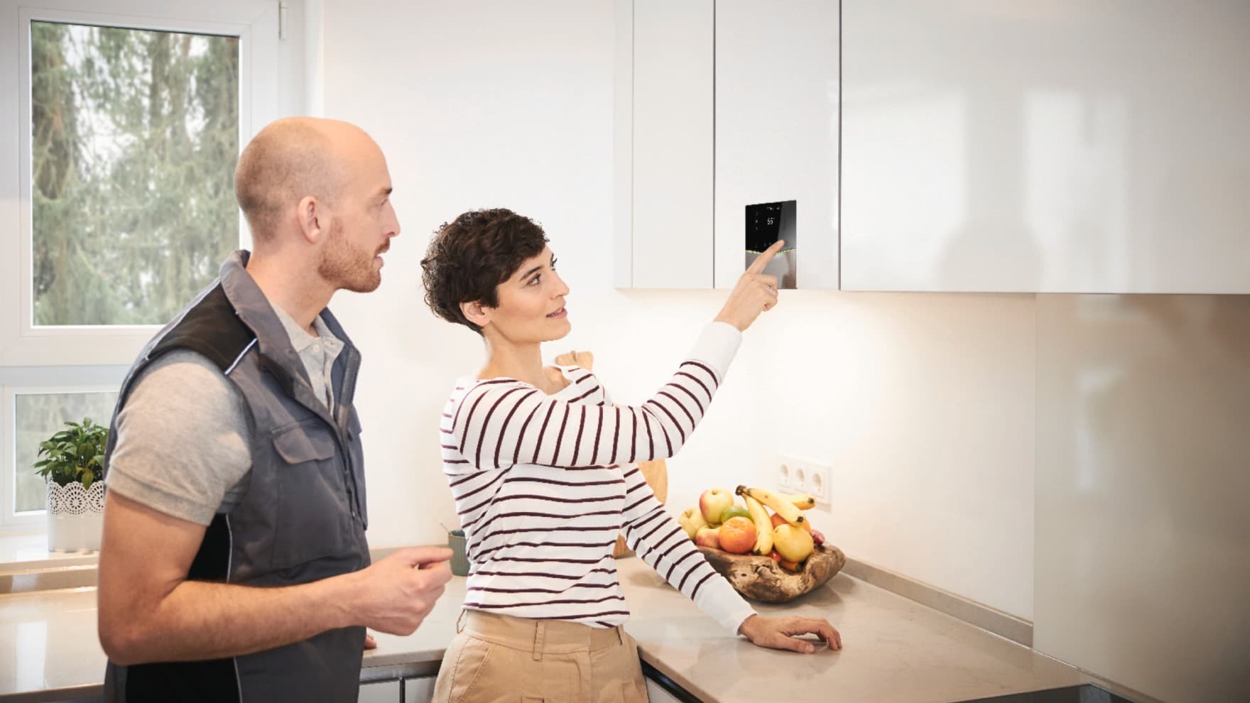 Vaillant Kundin zeigt einem Fachhandwerker einen Fehlercode auf einem Heizgerät.